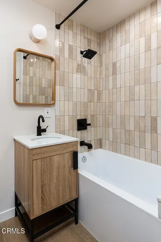 a bathroom with a bathtub a sink and mirror