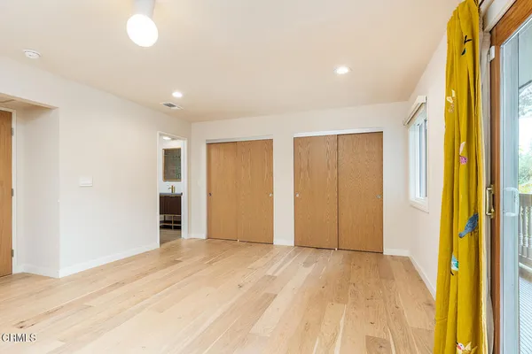 a view of empty room with wooden floor and windows