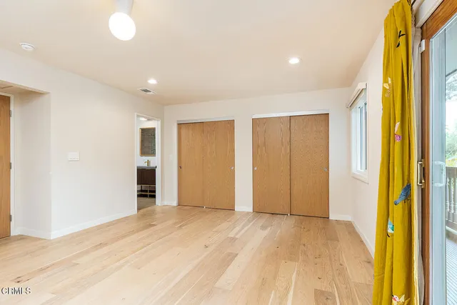 a view of empty room with wooden floor and windows