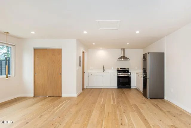 a view of a kitchen with refrigerator and a stove