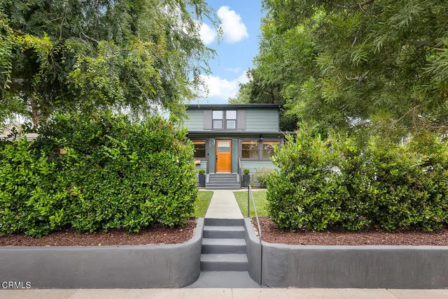 a front view of a house with a yard and trees