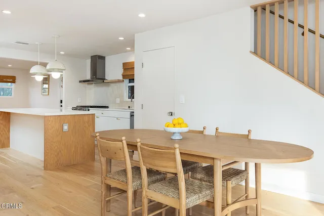 a kitchen with kitchen island a stove a table and chairs in it