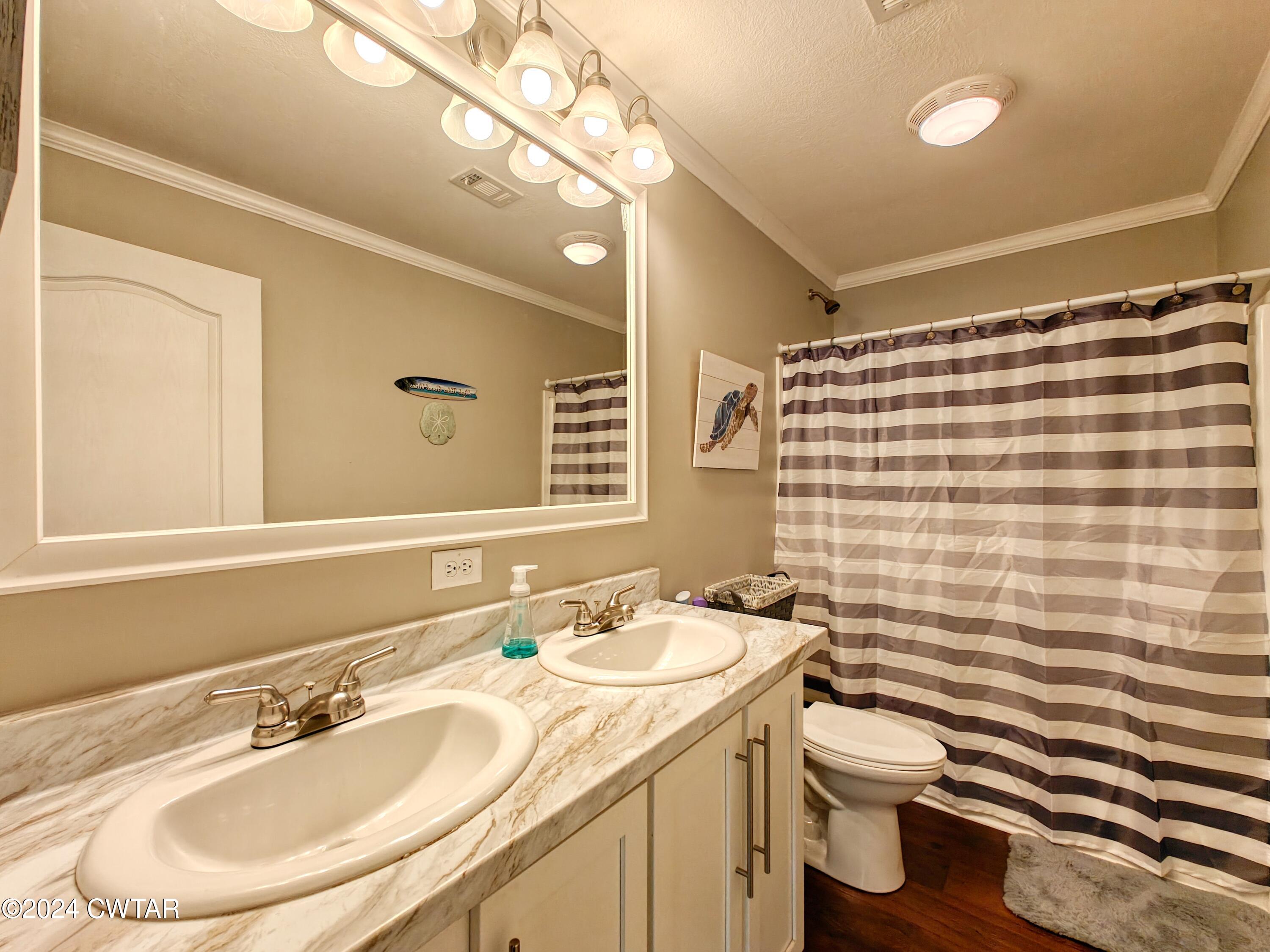 32 Jim Jackson Road Humboldt, TN 38343 - Photo 28 of 35 a bathroom with a sink a toilet a mirror and shower curtain