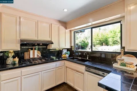a kitchen with sink a window and cabinets