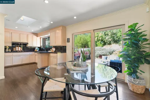 a kitchen with a dining table chairs and refrigerator