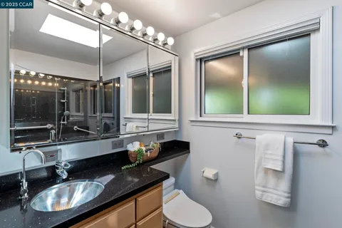 a bathroom with a toilet a sink and mirror