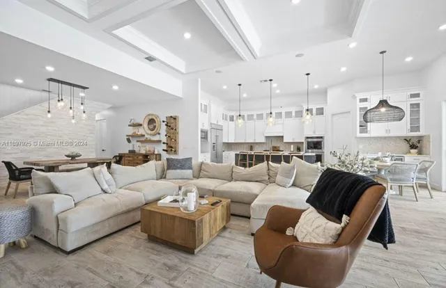 a living room with furniture and a view of kitchen