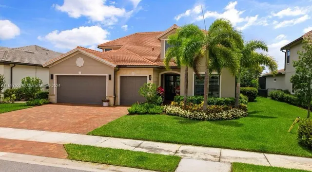 a front view of a house with a garden and plants
