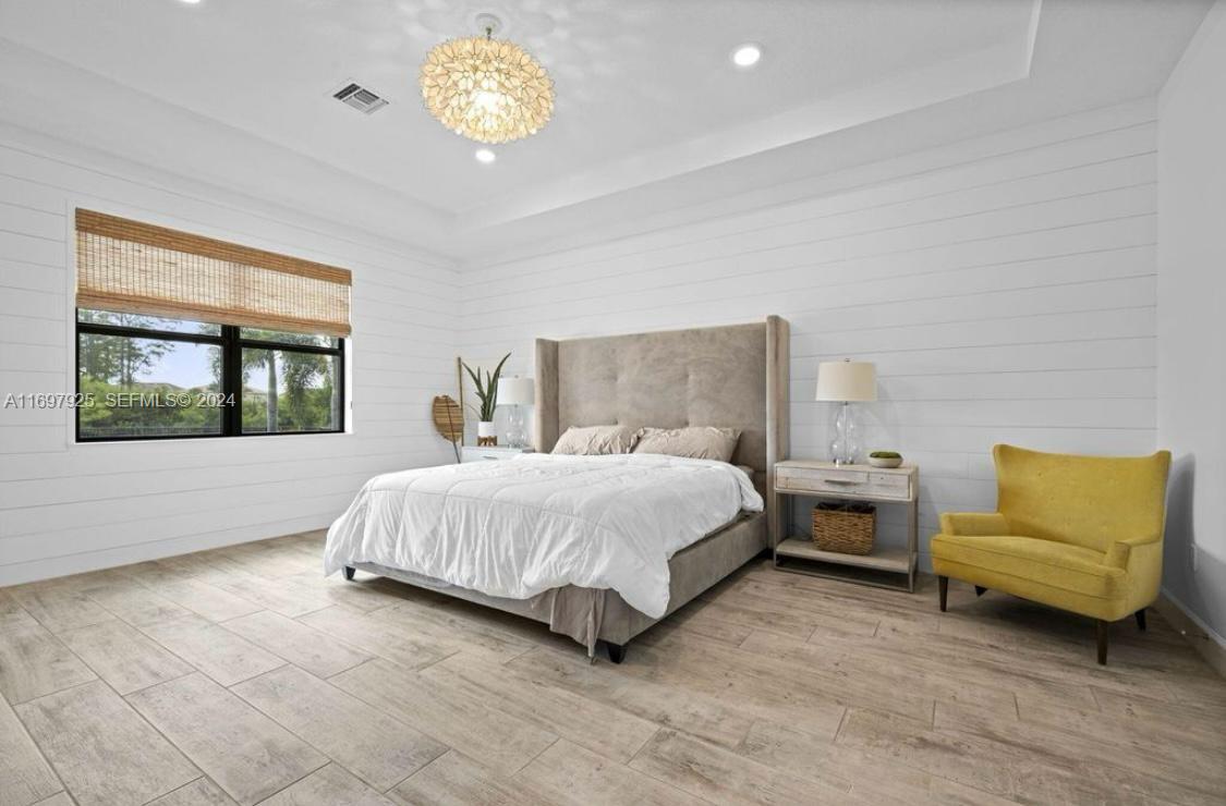141 Cinder Dunes Point Jupiter, FL 33478 - Photo 17 of 35 a spacious bedroom with a bed and a window