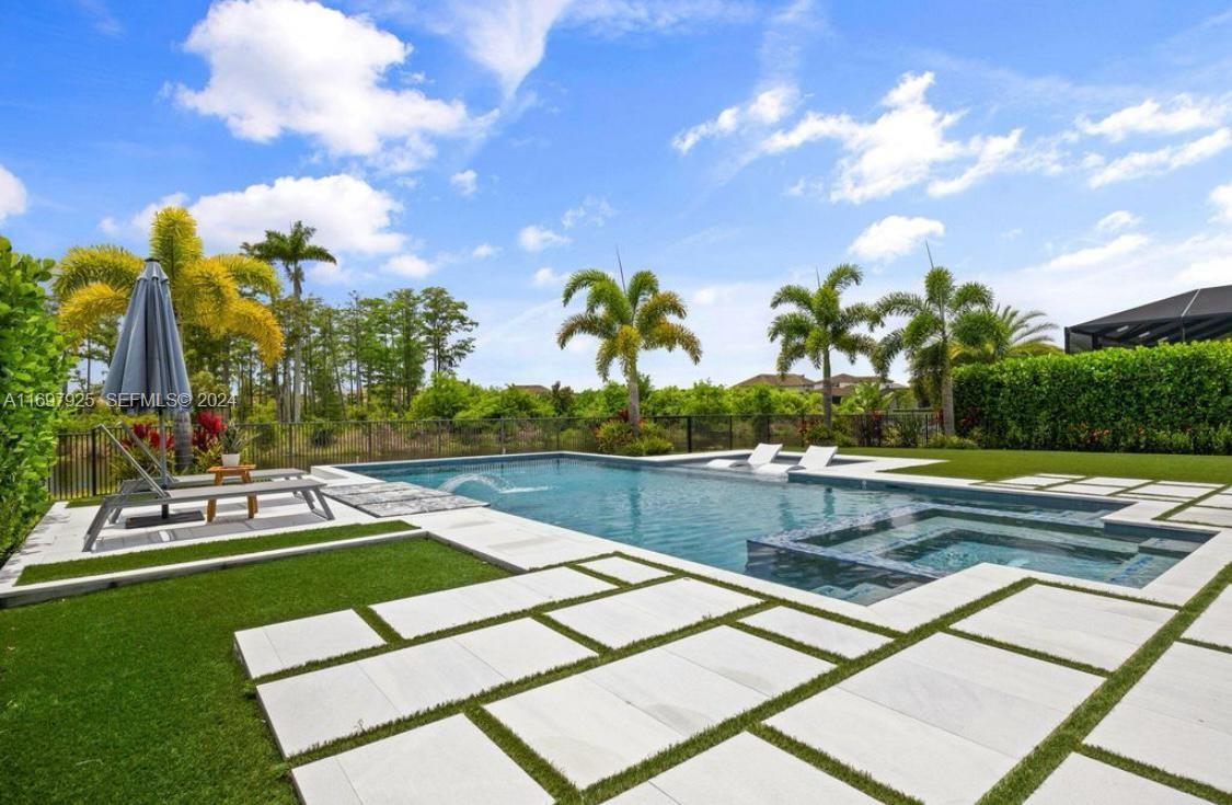 141 Cinder Dunes Point Jupiter, FL 33478 - Photo 2 of 35 a view of a swimming pool with a garden