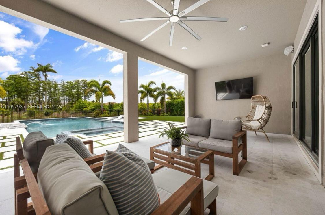141 Cinder Dunes Point Jupiter, FL 33478 - Photo 29 of 35 a living room with furniture tv and a large window