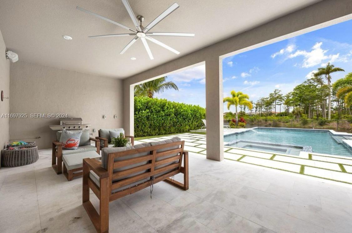 141 Cinder Dunes Point Jupiter, FL 33478 - Photo 30 of 35 a living room with furniture and a floor to ceiling window