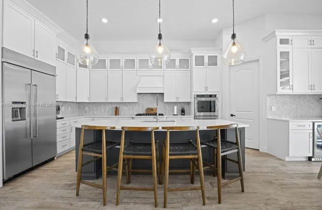 a kitchen with kitchen island cabinets and chairs in it