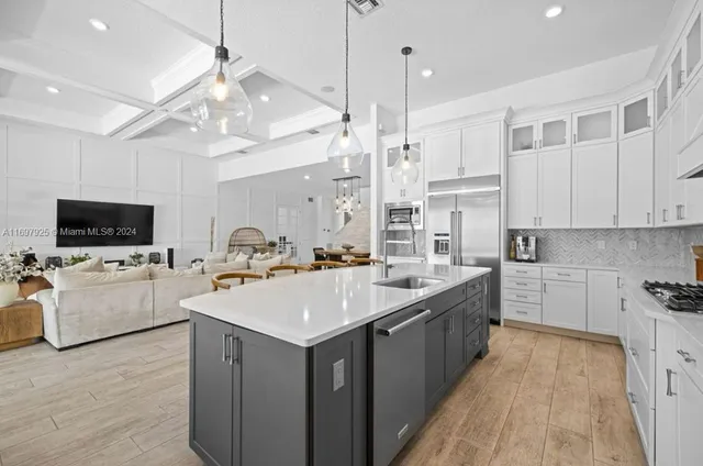 a large kitchen with kitchen island a sink a counter space and stainless steel appliances