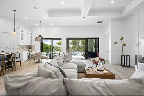 a living room with furniture wooden floor and large windows