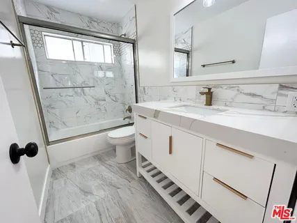 a spacious bathroom with a shower sink vanity mirror and toilet