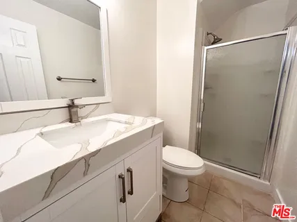a bathroom with a granite countertop sink toilet and shower