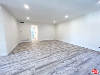 a view of an empty room with wooden floor