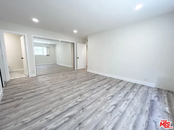 a view of empty room with wooden floor