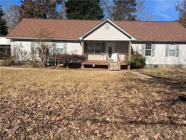 a white house covered with tall trees