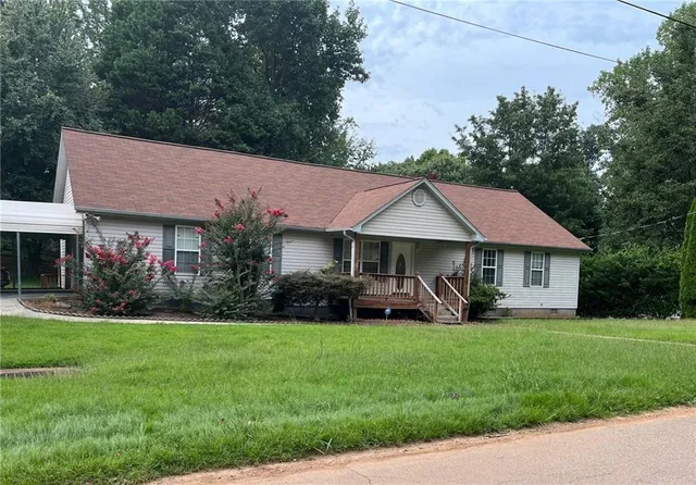 a front view of a house with a yard patio and green space