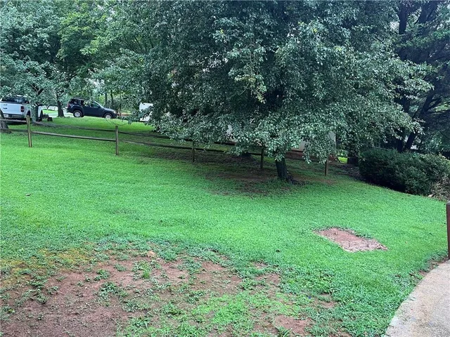 a backyard of a house with lots of green space and fountain
