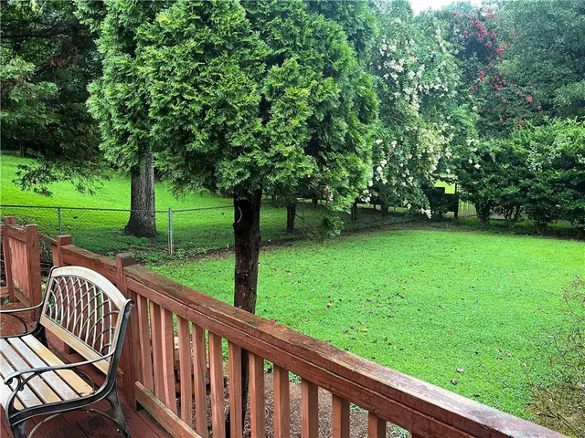 a view of a wooden deck and a backyard