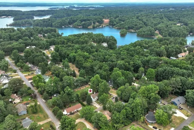 an aerial view of residential houses with outdoor space and trees