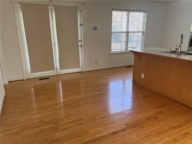 a view of a kitchen with wooden floor and cabinets