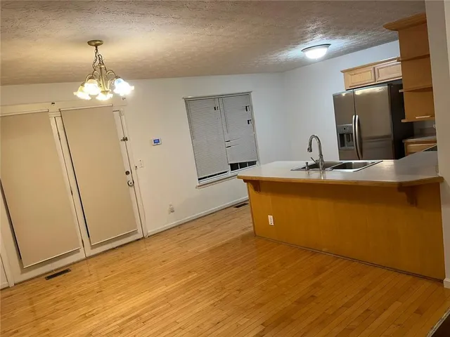 a room with wooden floor and chandelier