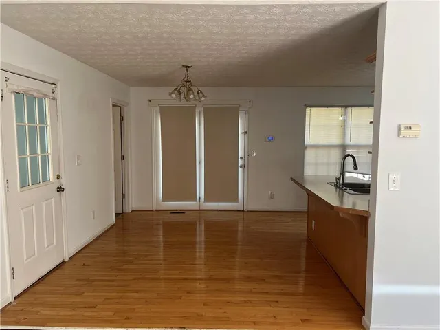 a view of a hallway with wooden floor and a living room