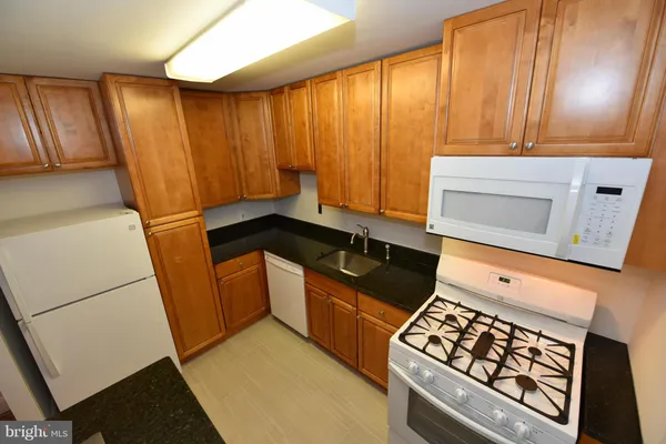 a kitchen with wooden cabinets and a stove top oven