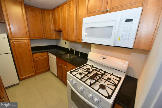 a kitchen with wooden cabinets and a stove top oven