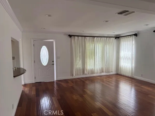 a view of a room with wooden floor and window