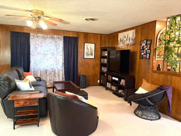 a living room with furniture a flat screen tv and a window