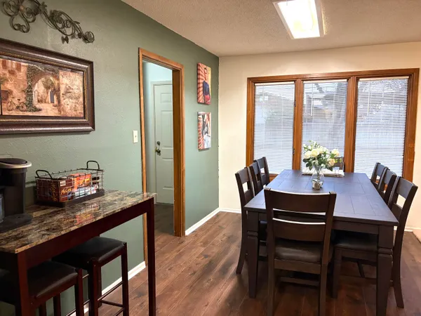 a dining room with furniture a rug and a potted plant