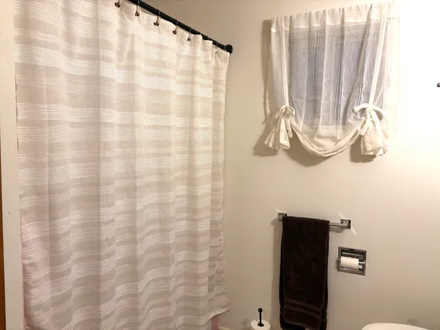 a bathroom with a shower curtain and a curtain