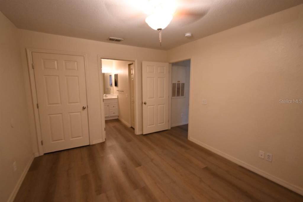 36047 Deer Creek Drive, Unit 102 Zephyrhills, FL 33541 - Photo 13 of 37 wooden floor in an empty room