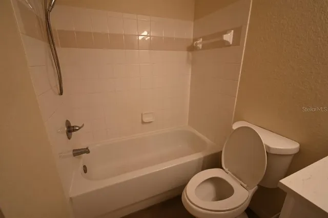 a bathroom with a toilet and a bath tub