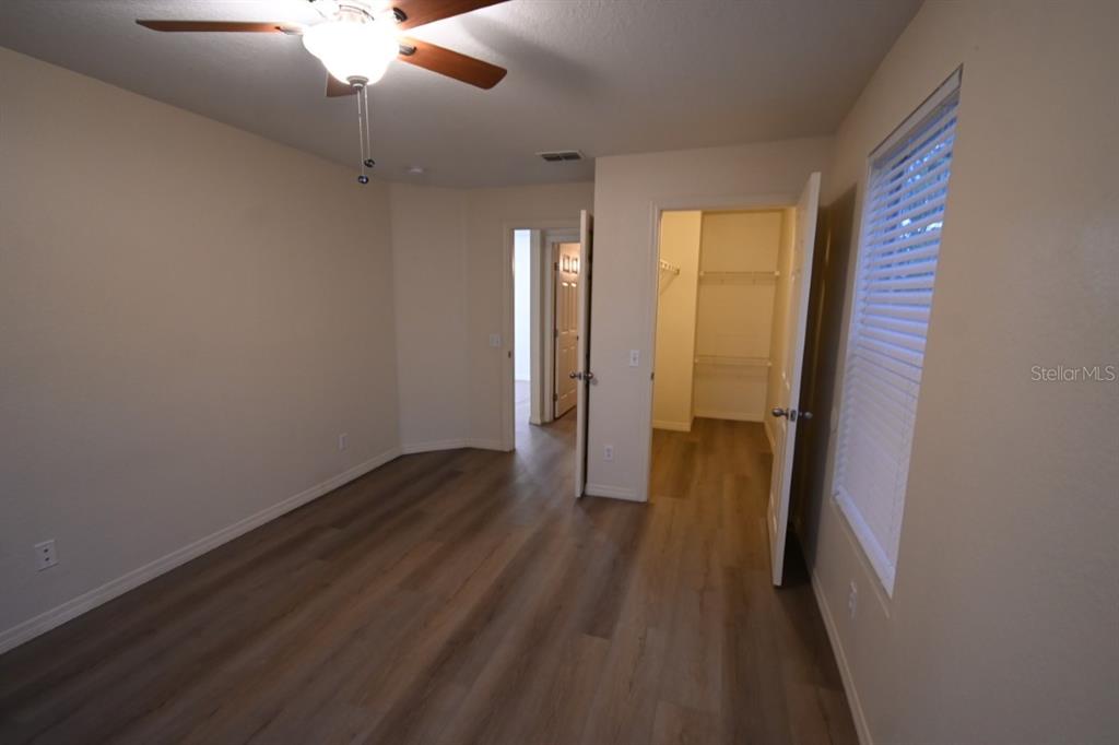 36047 Deer Creek Drive, Unit 102 Zephyrhills, FL 33541 - Photo 17 of 37 wooden floor in an empty room with a gallery