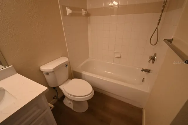 a white toilet sitting next to a bath tub and a shower