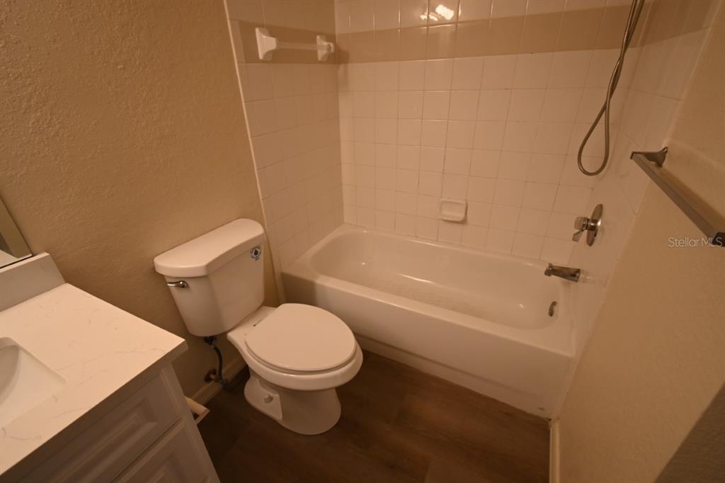 36047 Deer Creek Drive, Unit 102 Zephyrhills, FL 33541 - Photo 18 of 37 a white toilet sitting next to a bath tub and a shower