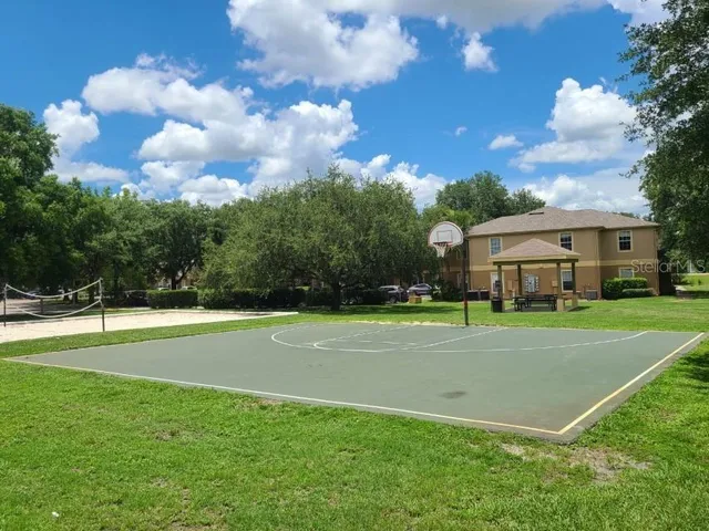 a view of a house with a big yard and a large trees