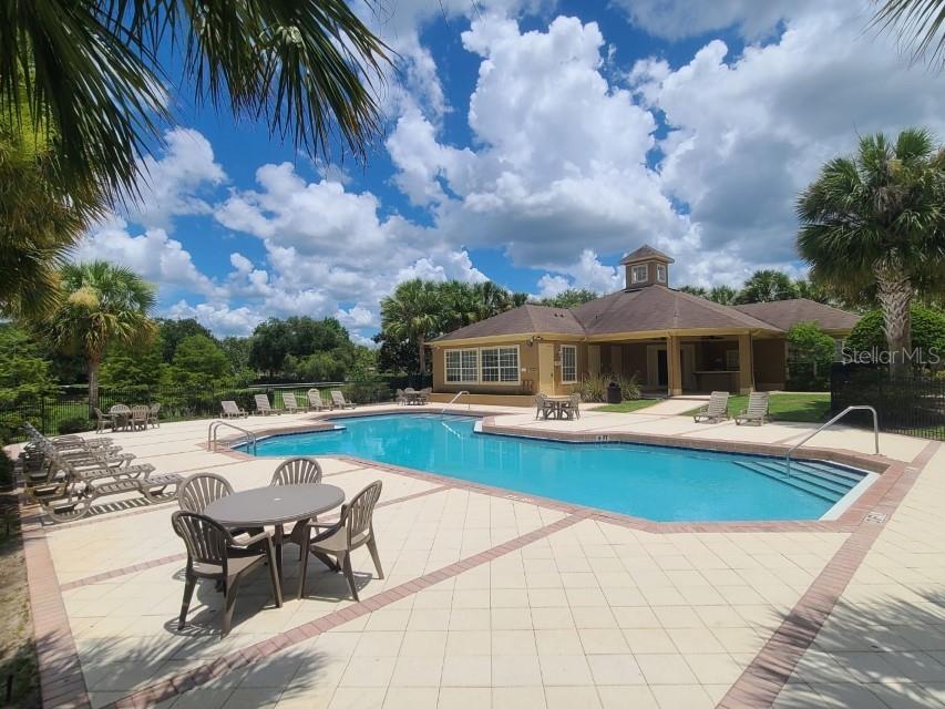 36047 Deer Creek Drive, Unit 102 Zephyrhills, FL 33541 - Photo 32 of 37 a view of a house with swimming pool and sitting area