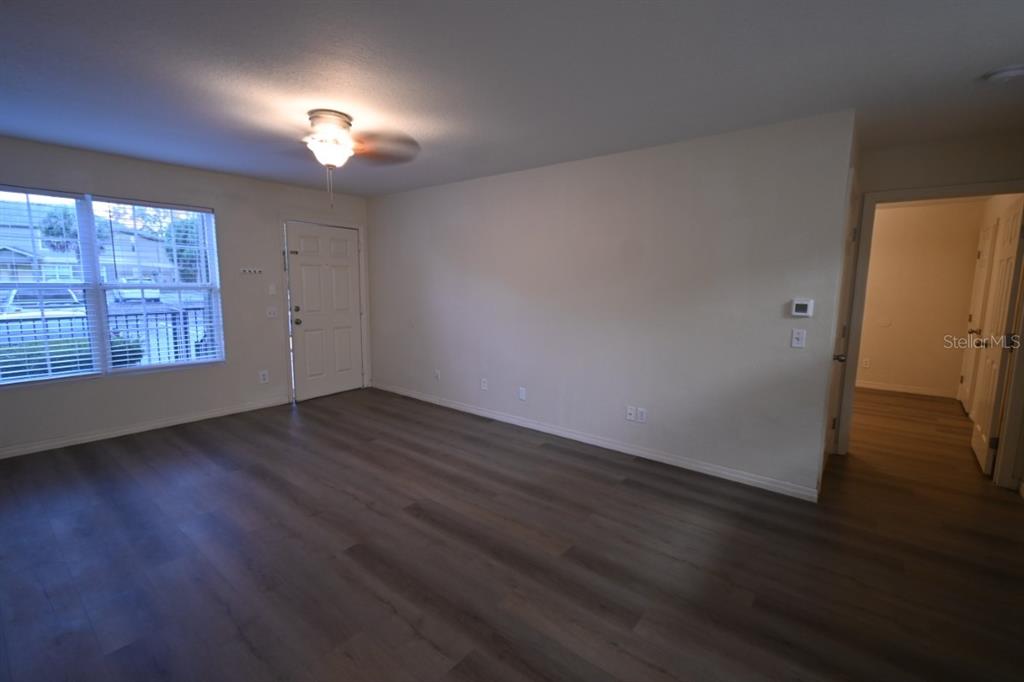 36047 Deer Creek Drive, Unit 102 Zephyrhills, FL 33541 - Photo 7 of 37 an empty room with wooden floor and windows