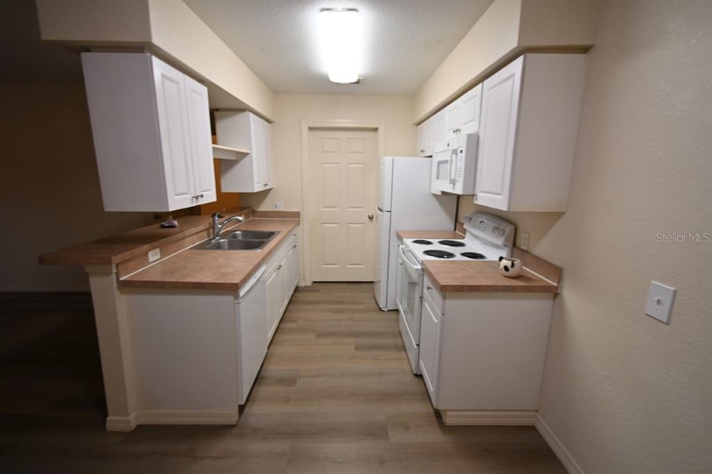 36047 Deer Creek Drive, Unit 102 Zephyrhills, FL 33541 - Photo 9 of 37 a kitchen with a sink stove and refrigerator