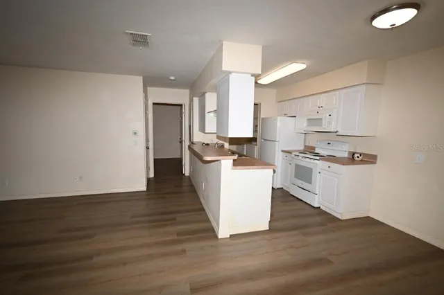a kitchen with granite countertop a stove top oven and cabinets