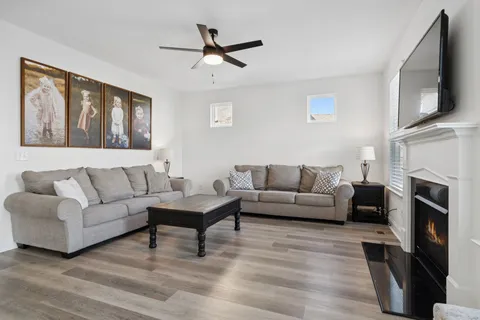 a living room with furniture a flat screen tv and a fireplace