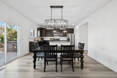 a view of a dining room with furniture a chandelier and wooden floor