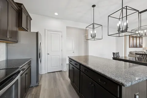 a kitchen with granite countertop a sink a counter space appliances and cabinets